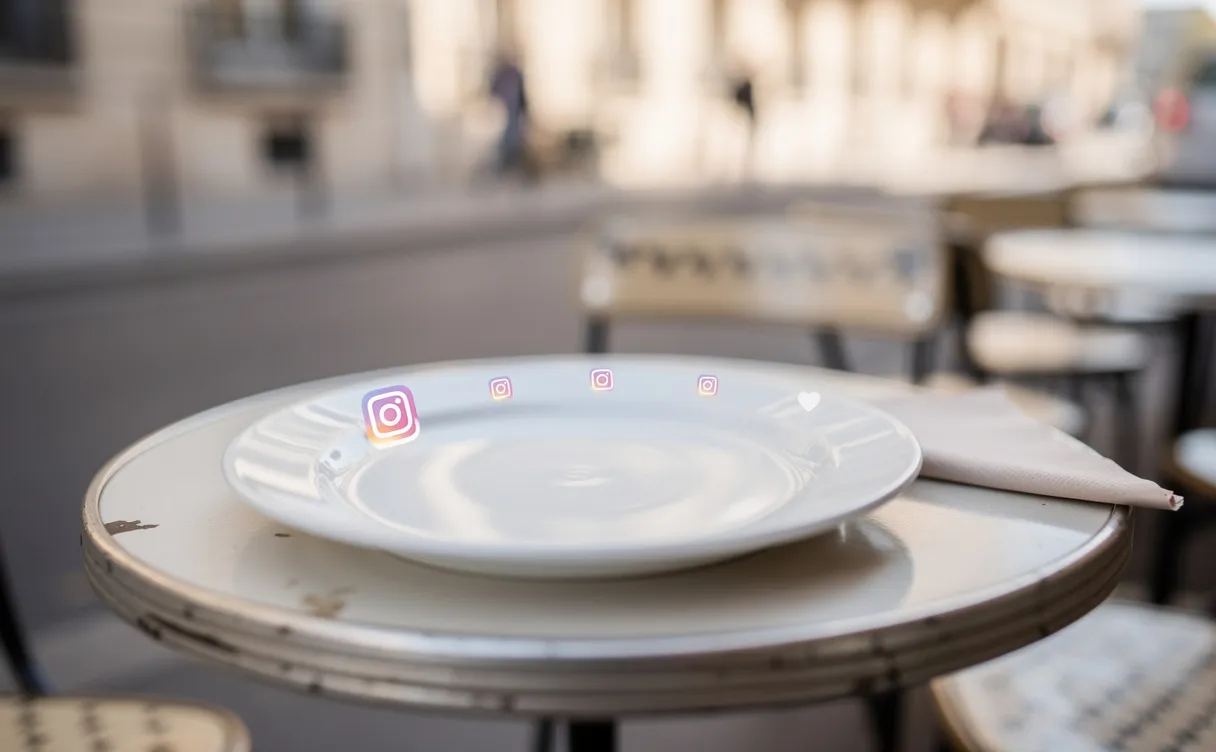 Assiette blanche en céramique posée sur une table de café parisien avec un reflet discret d’icônes Instagram sur sa surface.