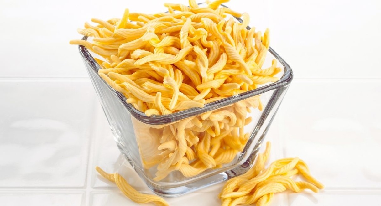 Spaetzle jaunes en forme de petites pates irregulieres dans un bol en verre